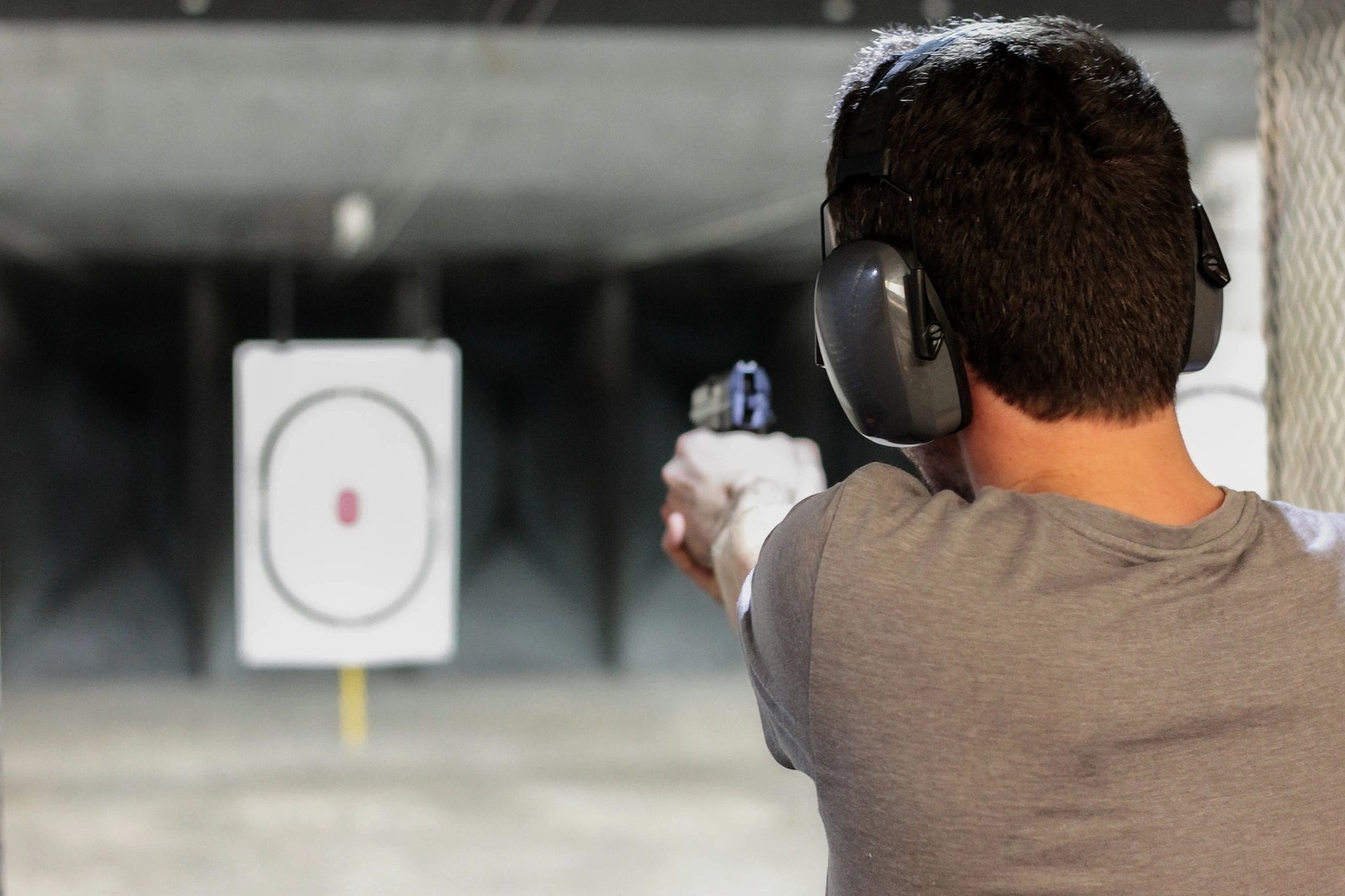 A man is holding his gun up to the side of his face.